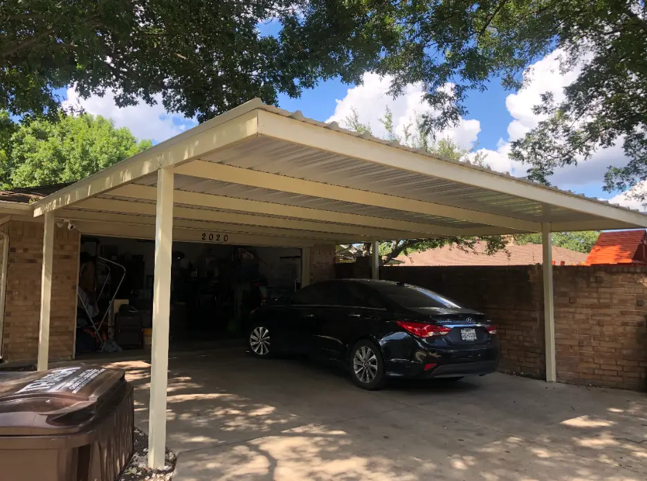 Flat-roof white carport attached to a brick home with a dark sedan parked underneath