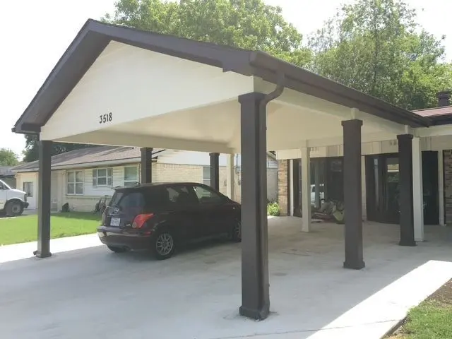 Gable-roof carport with dark columns covering a driveway and parked SUV