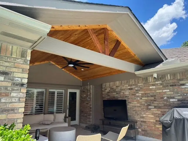 Cedar truss patio cover with an outdoor TV and lounge furniture