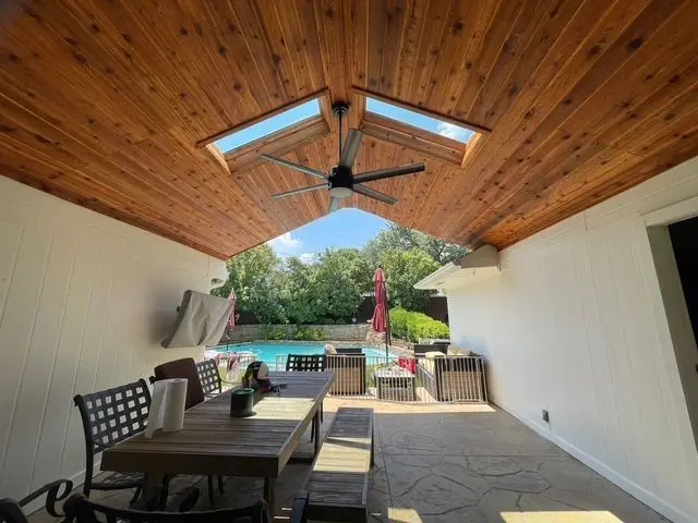 Cedar patio ceiling with a skylight above a dining table near the pool