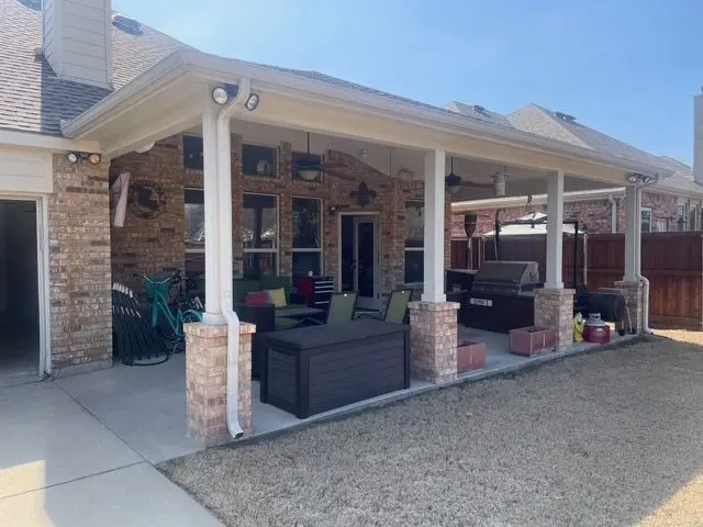 Covered patio with white columns on brick bases and outdoor seating