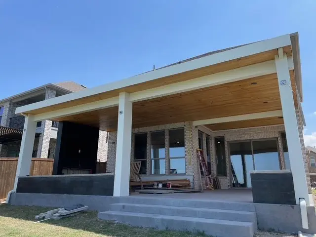 White-column patio cover over a raised concrete patio with steps
