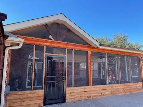 Front of a cedar-trimmed screen room with a gable roof and wood knee wall