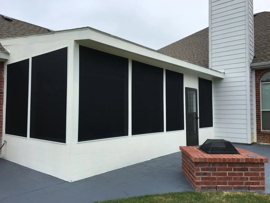 White screen room with black screens beside a brick fire pit