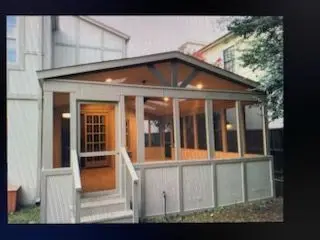 Screened porch with a gable roof, wood trim, and entry steps