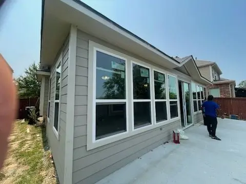 Sunroom addition with lap siding and a row of large windows