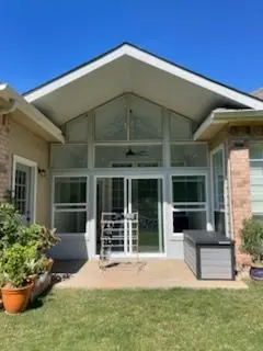 Gable-front sunroom with floor-to-ceiling glass and French doors