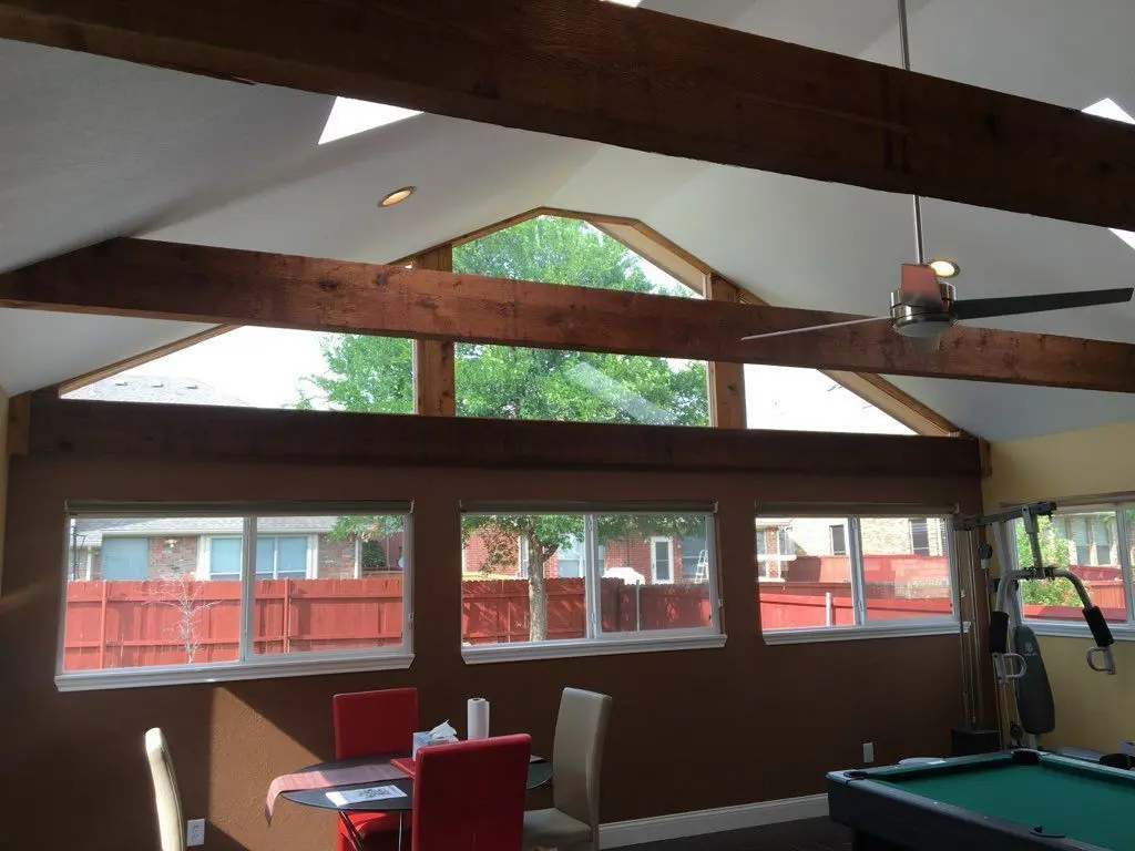 Sunroom interior with exposed wood beams, clerestory windows, and a pool table