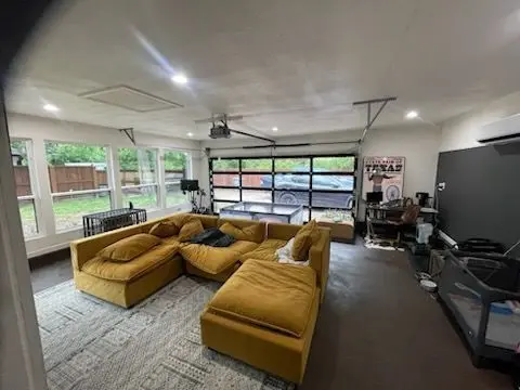 Sunroom lounge with a sectional sofa and a glass garage-style door