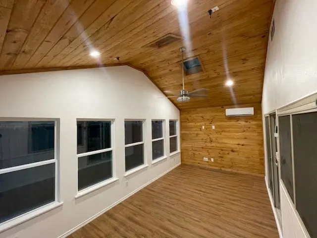 Sunroom interior with a tongue-and-groove wood ceiling and wraparound windows